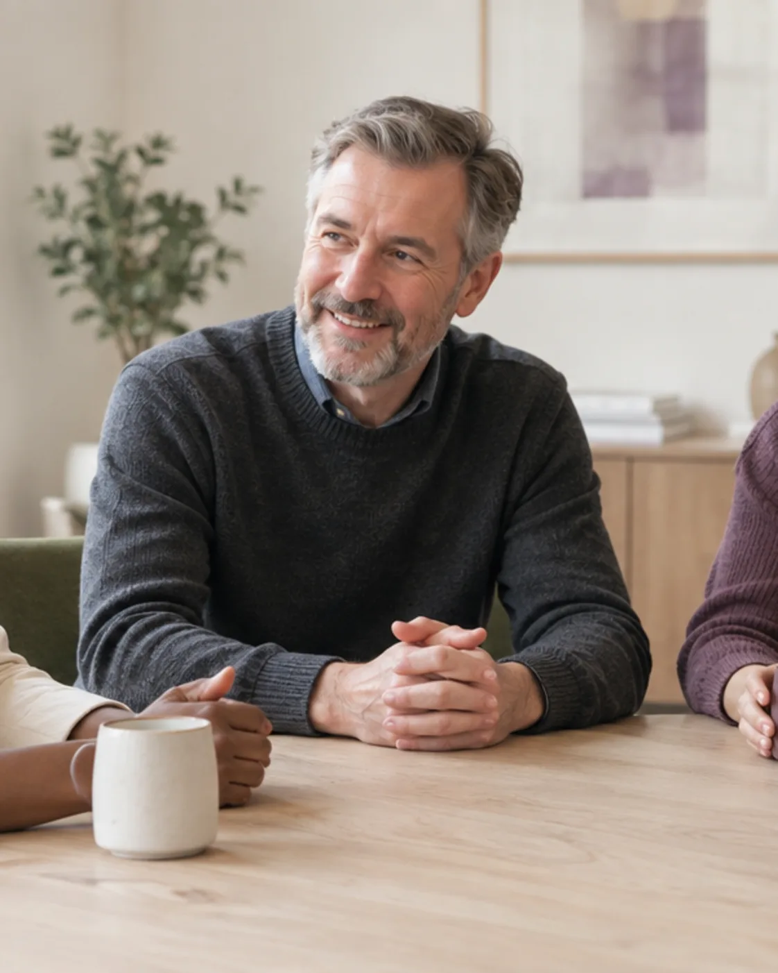 Three senior colleagues talking around a table