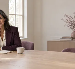 Two people talking across a meeting table